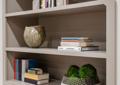 Omaha Home, Kitchen, Bathroom and Basement Remodeling - A modern shelving unit displaying a neatly organized collection of books and decorative items, with elegant cabinetry below.